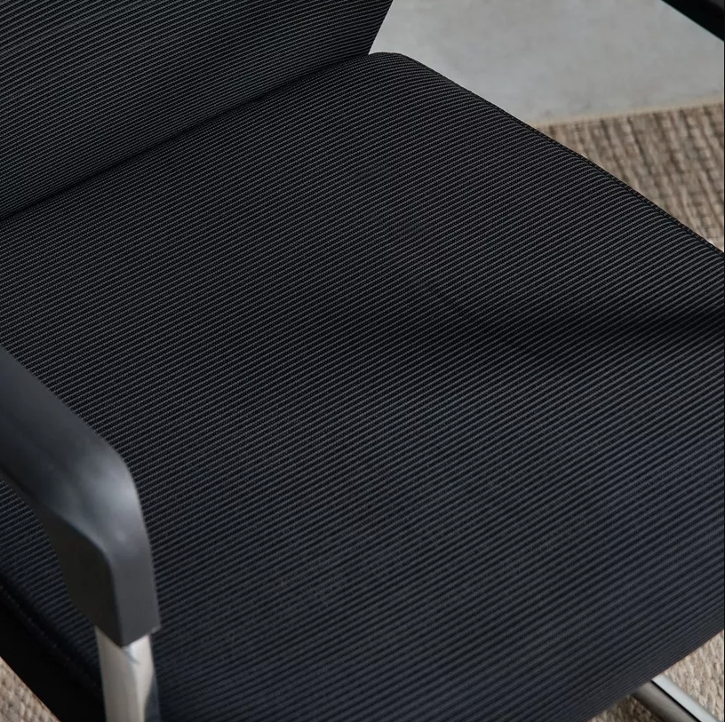 Close-up of a textured black chair cushion on a chair.