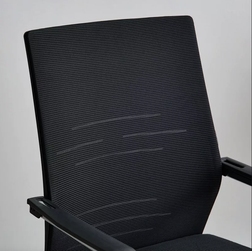 Black office chair with mesh backrest on a plain background