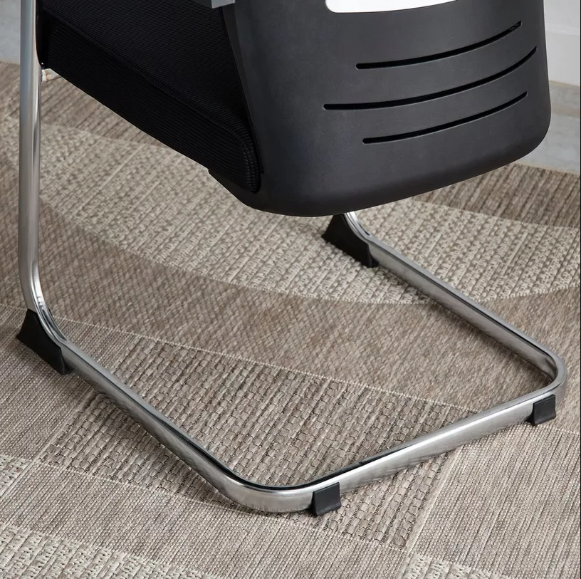 Black office chair with metal frame on a textured carpet