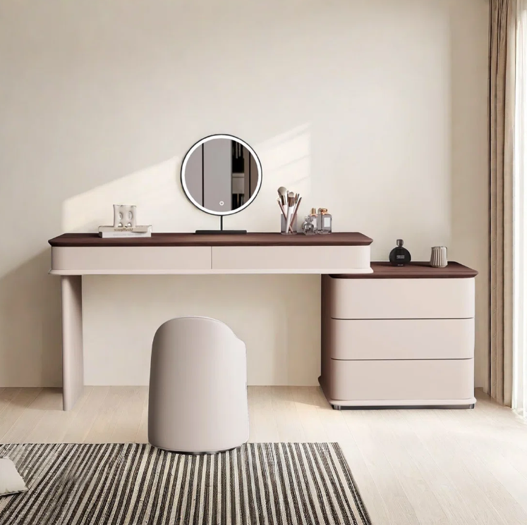 Modern vanity table with round mirror and decorative items in a minimalistic room.