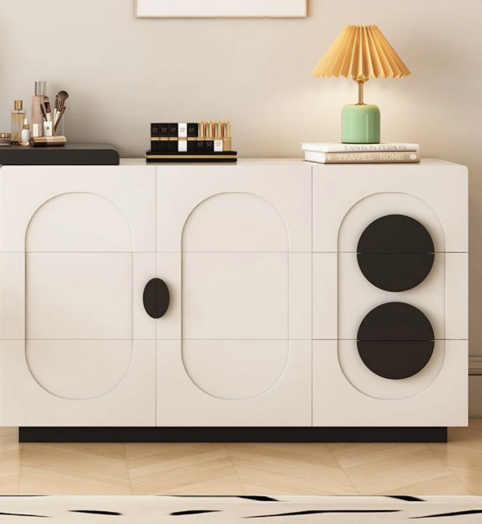 Modern white sideboard with black circular designs on a neutral background