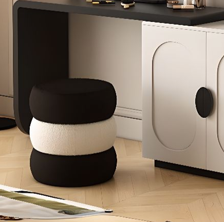 Modern vanity setup with a black desk, round mirror, and white cabinet with black accents.