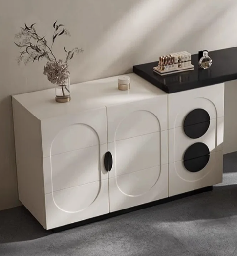 Modern interior with a white cabinet, black desk, and white ottoman.