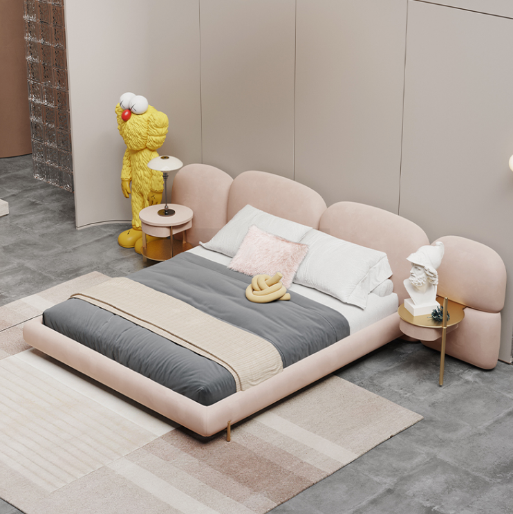 Modern bedroom with a pink bed, gray bedding, and decorative items.