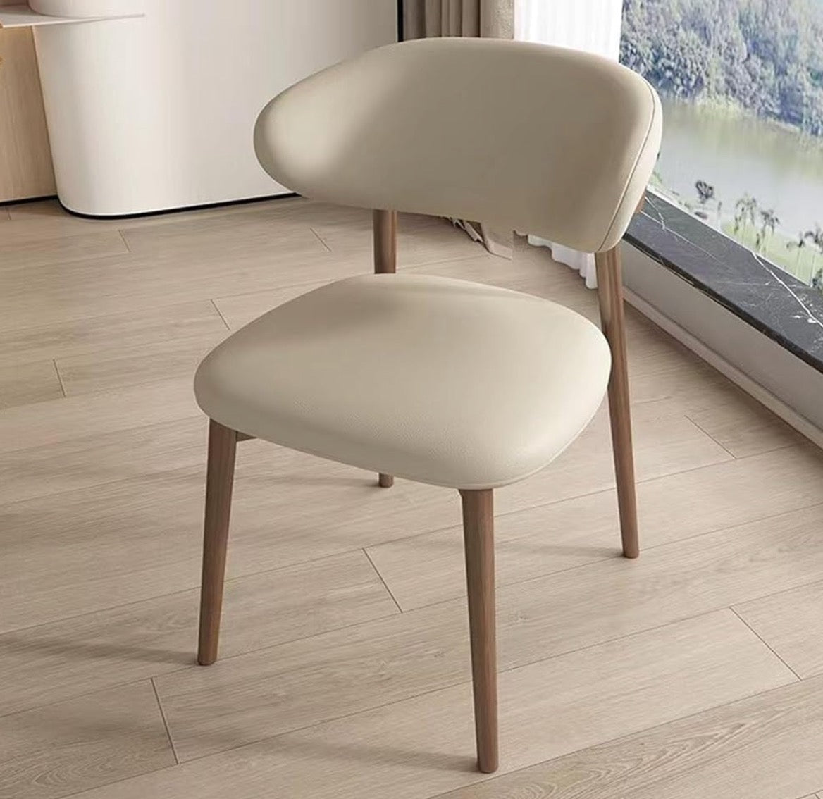 Beige chair with wooden legs on a light wood floor.