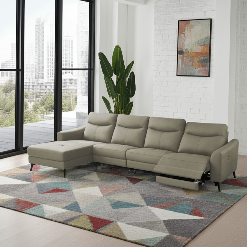 Beige sectional sofa in a modern living room with a geometric rug and large windows.