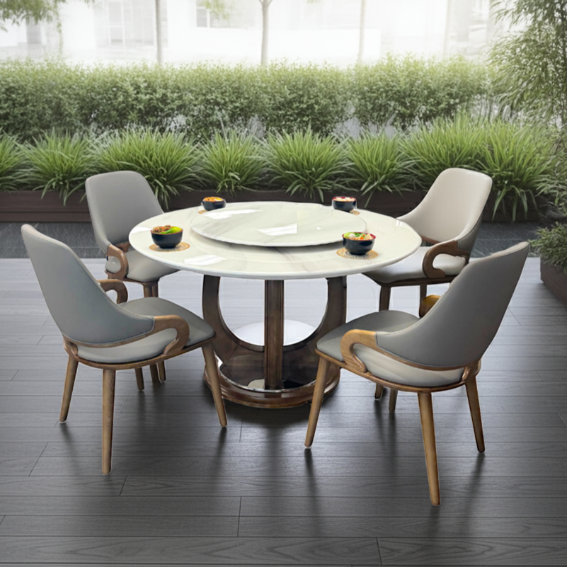 Round dining table with four chairs on a wooden deck surrounded by greenery