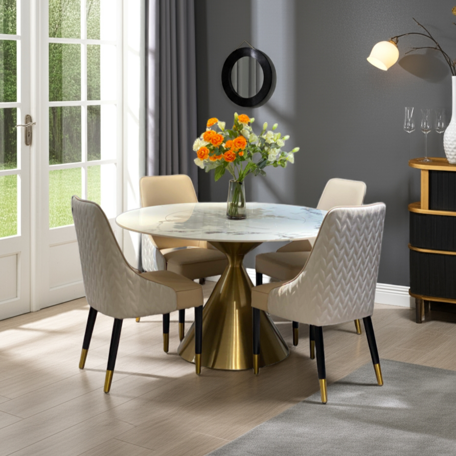 Dining room with a round marble table and gold base, surrounded by beige chairs.