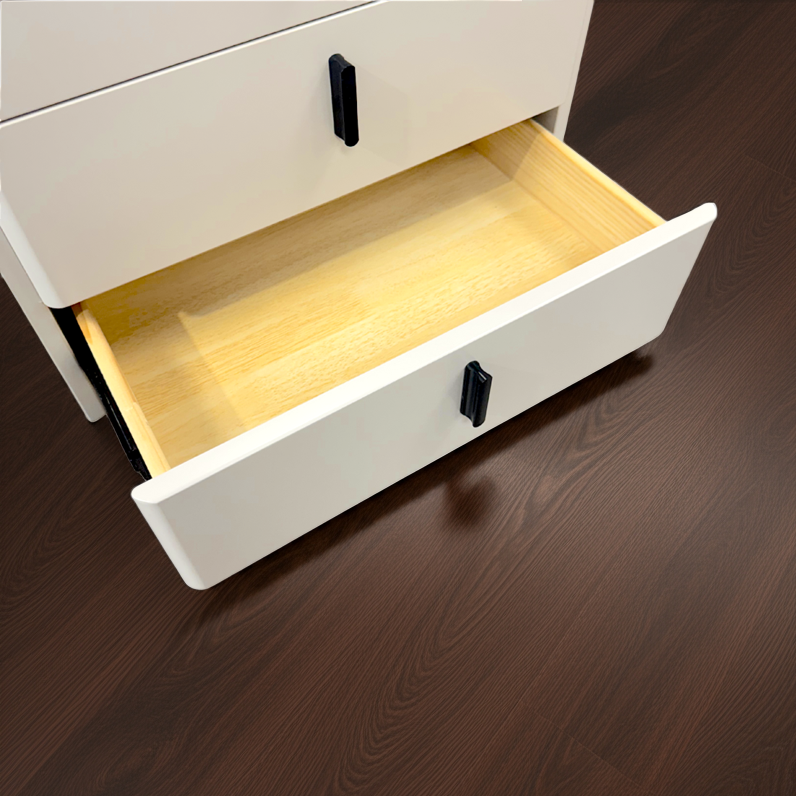 White dresser with an open drawer on a wooden floor