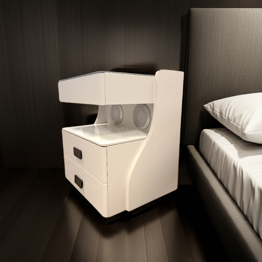 Modern white nightstand with speakers next to a bed in a dimly lit bedroom.