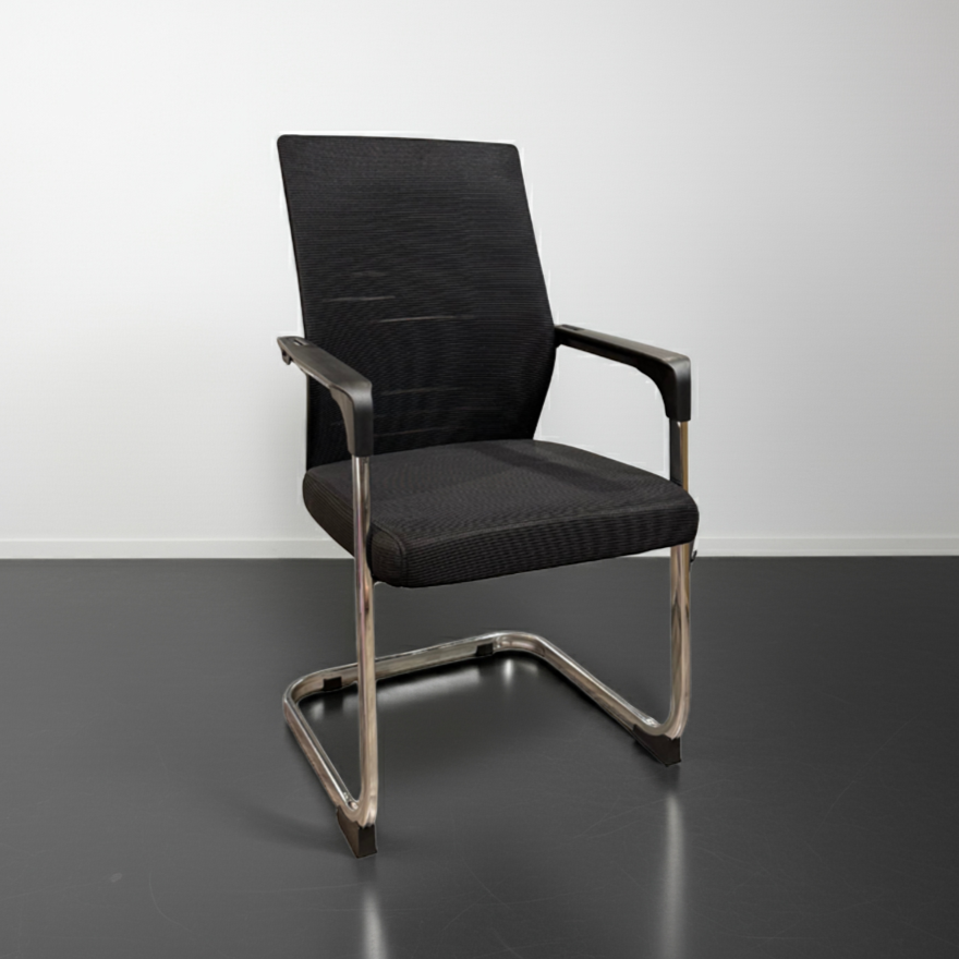 Black office chair with metal frame on a gray floor and white wall