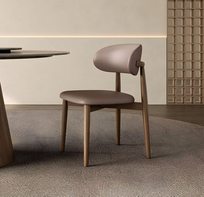Modern chair with wooden frame and brown seat in a minimalistic room.