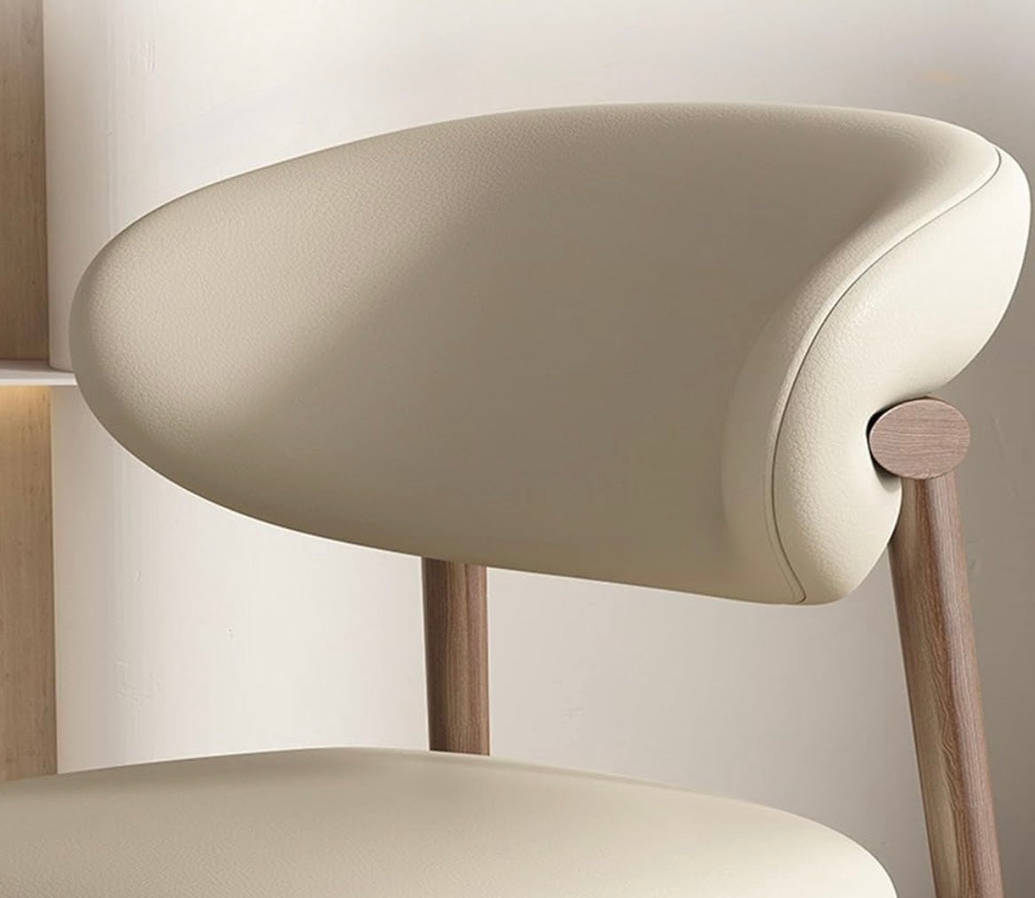 Beige chair with wooden legs against a neutral background
