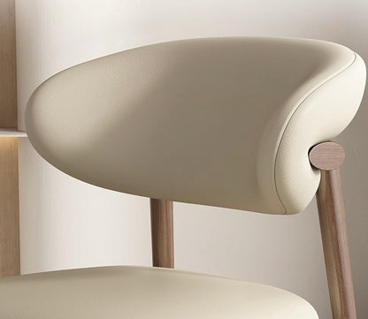 Beige chair with wooden legs against a neutral background
