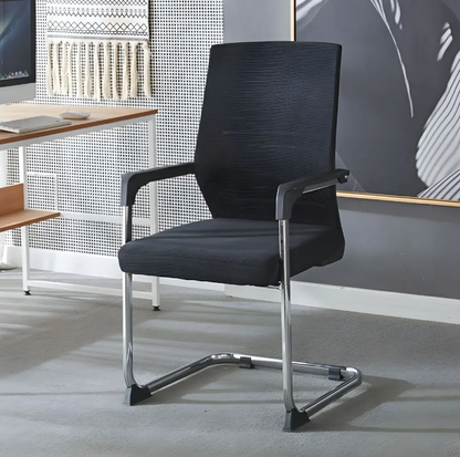 Black office chair in a modern office setting with a desk and wall art.
