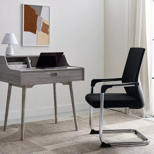 Modern office desk with a laptop and black chair in a room with a painting on the wall.