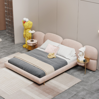Modern bedroom with a pink bed, gray bedding, and decorative items.