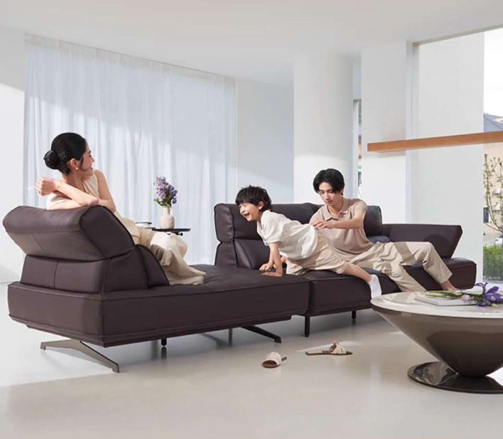 Family sitting on a modern brown leather sofa in a bright living room genesis furniture