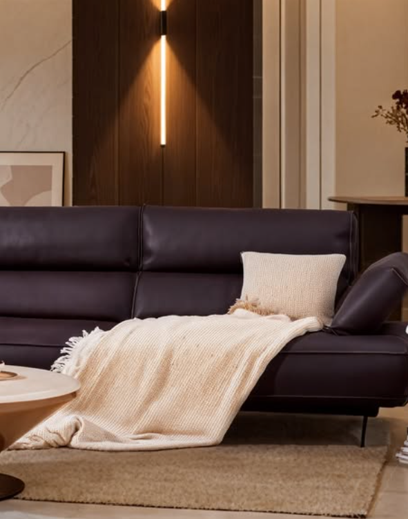 Modern living room with a dark brown sectional sofa, beige blanket, and pillow genesis furniture