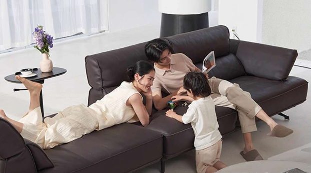 Family of three relaxing on a brown sectional sofa in a modern living room genesis furniture
