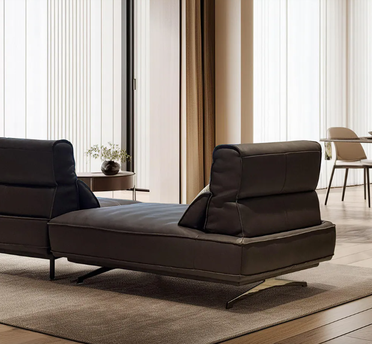 Brown leather chaise lounge in a modern living room setting with a dining area in the background genesis furniture 