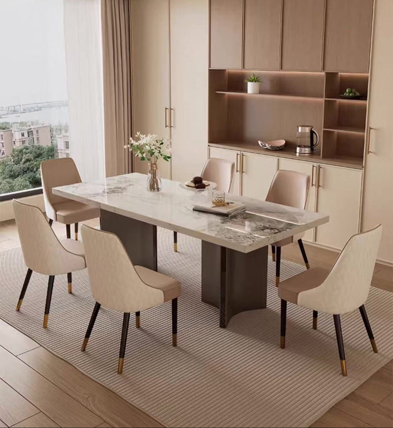 Modern dining room with marble table and beige chairs near a window with a view of buildings.