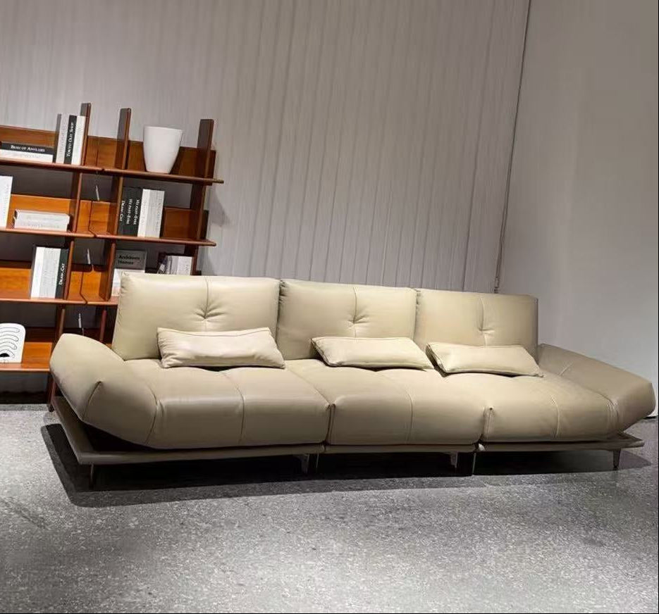 Beige sofa in a room with a bookshelf against a white wall genesis furniture