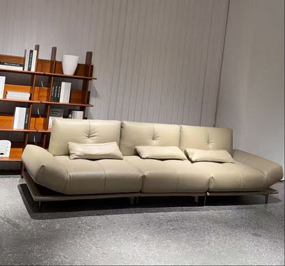 Beige sofa in a room with a bookshelf against a white wall genesis furniture