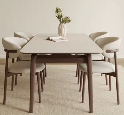Dining table set with six chairs in a minimalistic room.