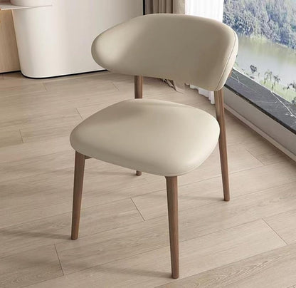 Beige chair with wooden legs on a light wood floor.