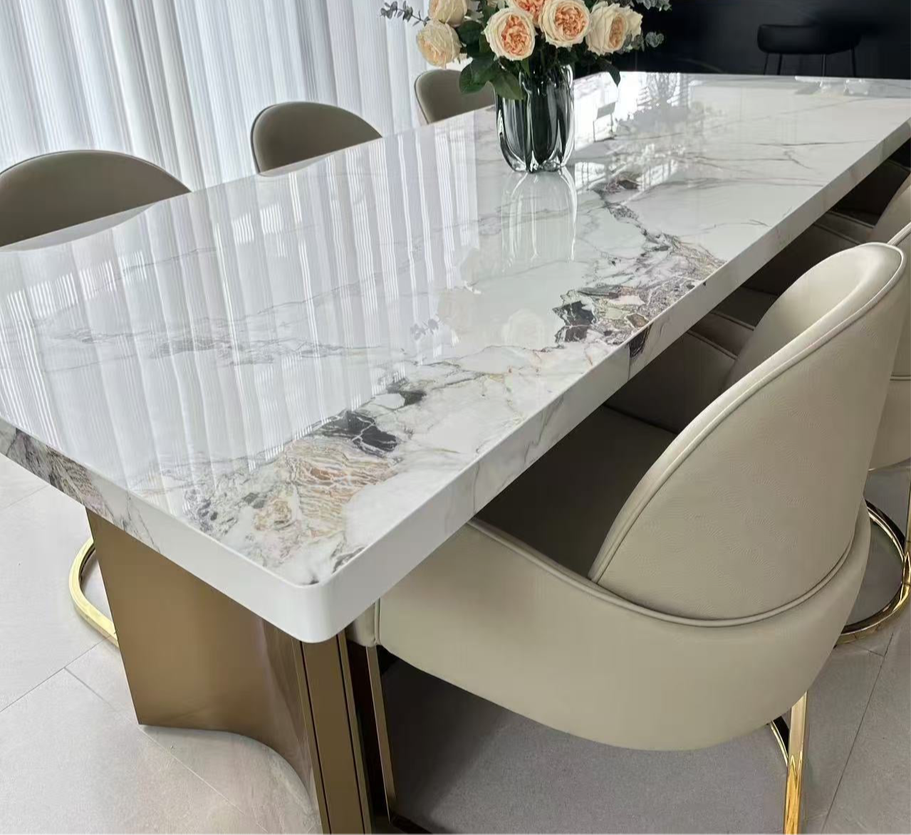 Dining table with marble-like surface and chairs in a modern kitchen setting