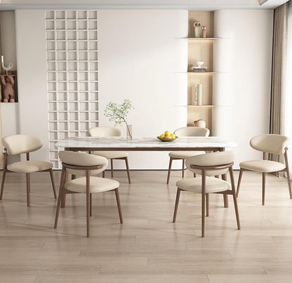 Modern dining room with a long table and chairs in a minimalistic setting.