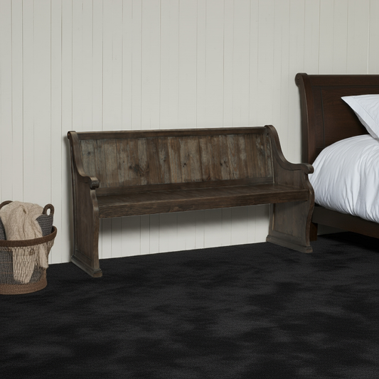 Wooden bench in a bedroom setting with a bed and basket in the background.