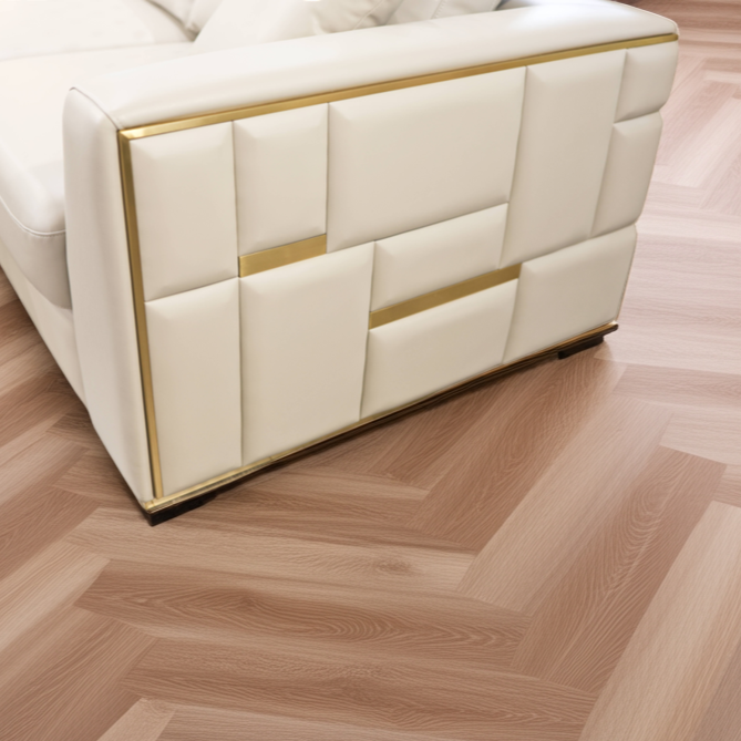 Wooden floor with a herringbone pattern and a white upholstered chair.