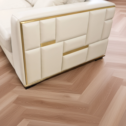 Wooden floor with a herringbone pattern and a white upholstered chair.
