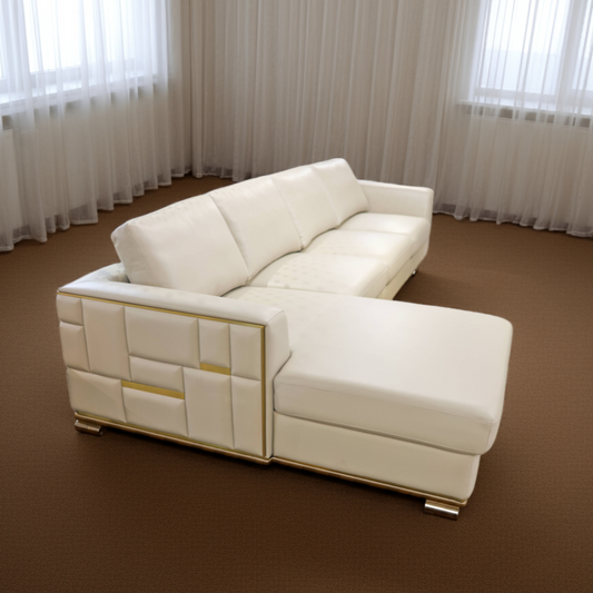 White sectional sofa in a room with brown carpet and white curtains.