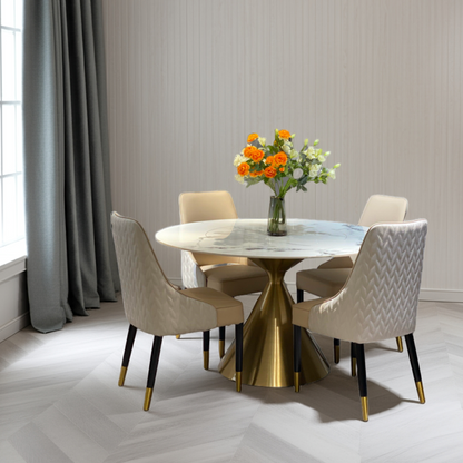 Dining room with a round marble table and gold base, surrounded by four chairs.