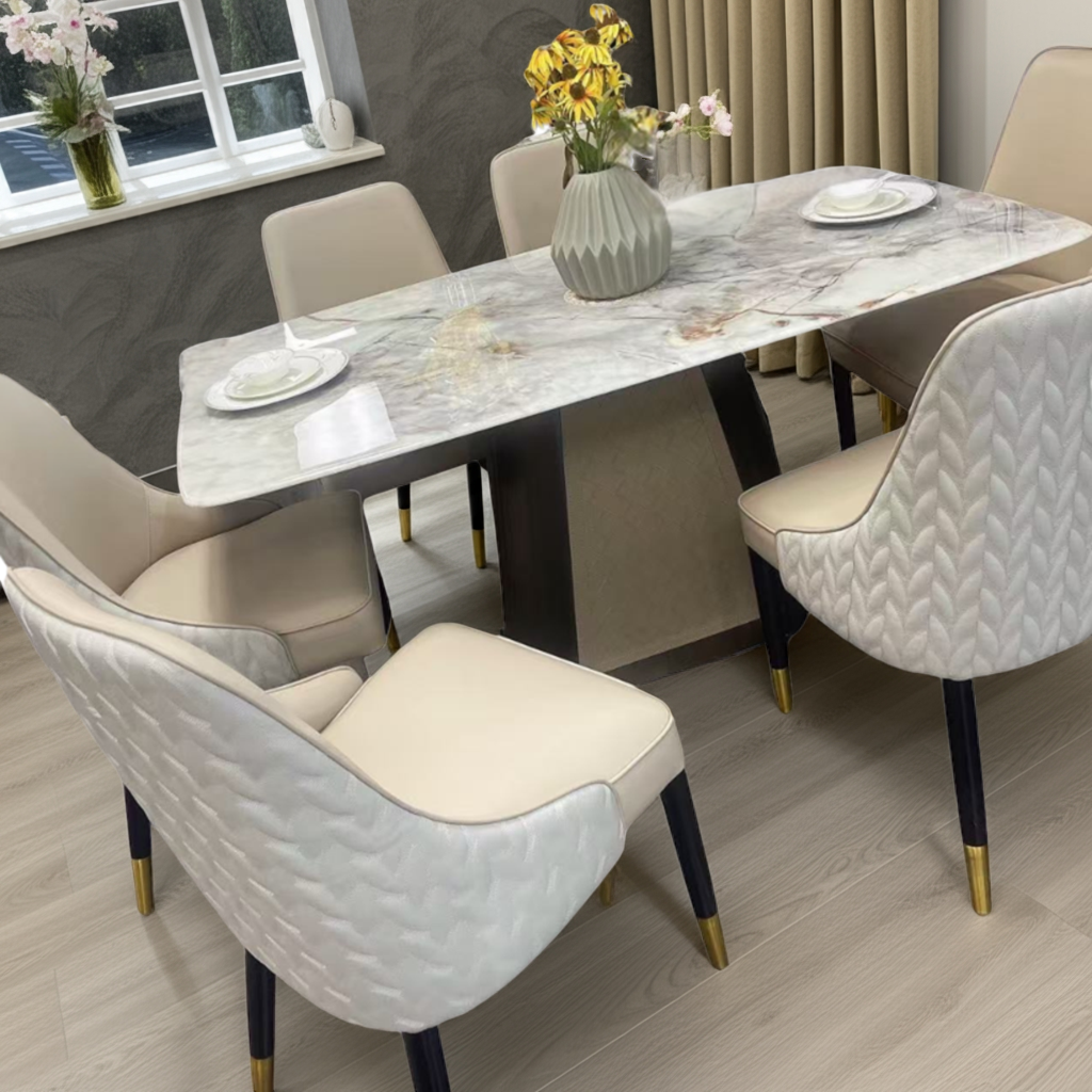 Dining room setup with a marble table and beige chairs.