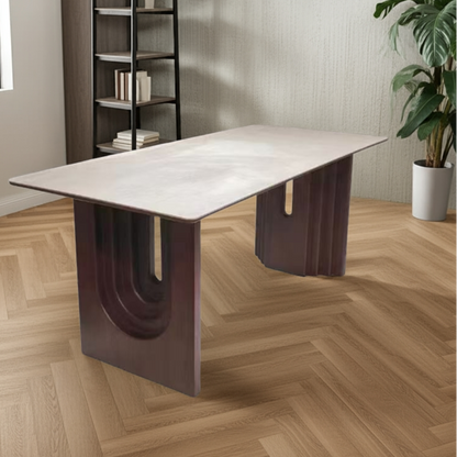 Modern dining table with unique U-shaped legs in a room with a bookshelf and plant.