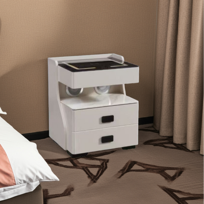 White nightstand with two drawers next to a bed in a bedroom setting.