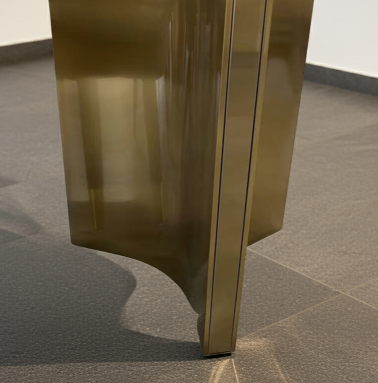 Gold metallic object on a gray tiled floor