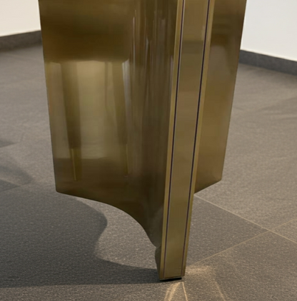 Gold metallic object on a gray tiled floor