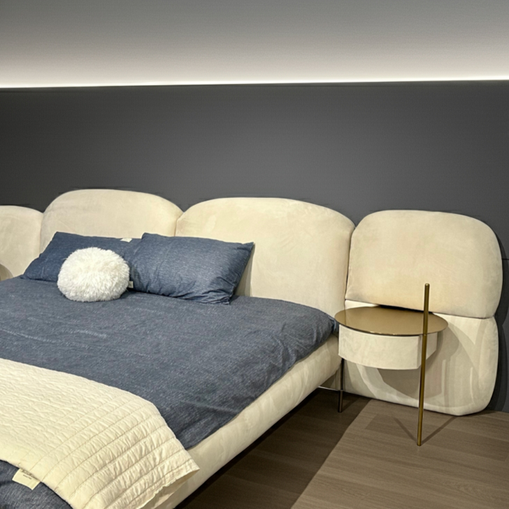 Modern bedroom with a bed, nightstands, and wall-mounted light fixture.