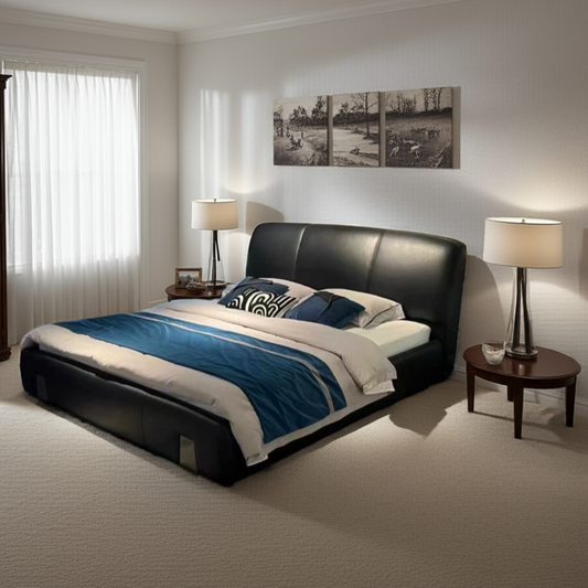 Modern bedroom with a black leather bed, white bedding, and two lamps.