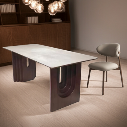 Modern dining table with a chair in a dimly lit room with a chandelier.